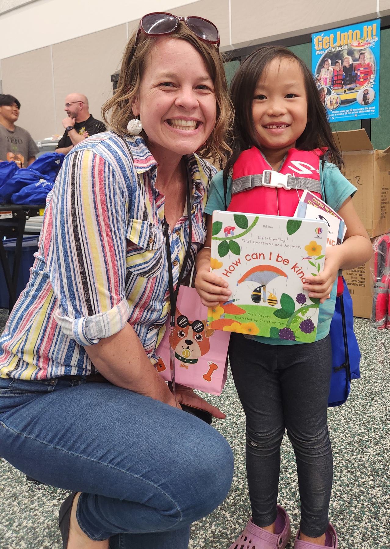 LPC Coodinator Anna Carson with a happy kid with a new book and lifejacket